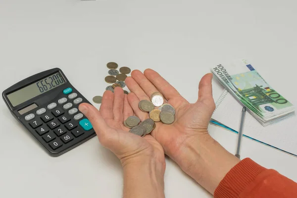 W palmach męskich znajdują się niewielkie monety, obok kalkulatora i banknotów euro. Koncepcja - podzbiór pieniędzy, podział dochodów. Koncepcja biznesu. Rubel — Zdjęcie stockowe