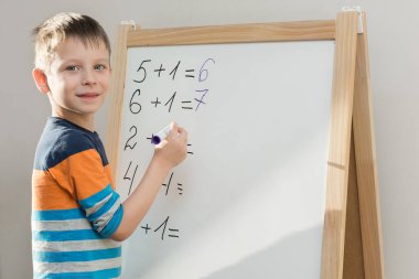 Anaokulu çocuğu cevabı tahtaya bir kalemle yazarak matematik örneği çözer. Çocuk çerçeveye bakar, tatmin olur, gülümser. Ana fikir evde okul için gerekli bilgiyi elde etmektir.