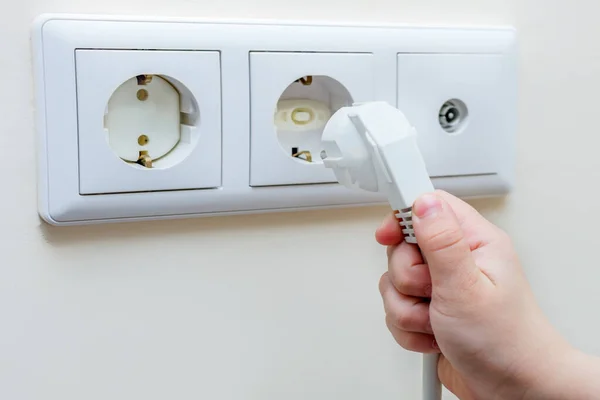 Elektrikli aletin fişi çocuğun elinde, çocuk fişi prize takmaya çalışıyor, soket çocuklardan korunuyor. Amaç, evi çocuklar için güvenli hale getirmek.