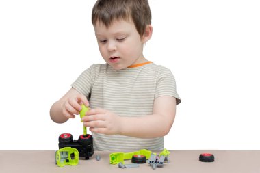 Çocuk oyuncak makinesini tamir ediyor. Fotoğraf yatay, beyaz üzerine izole edilmiş.