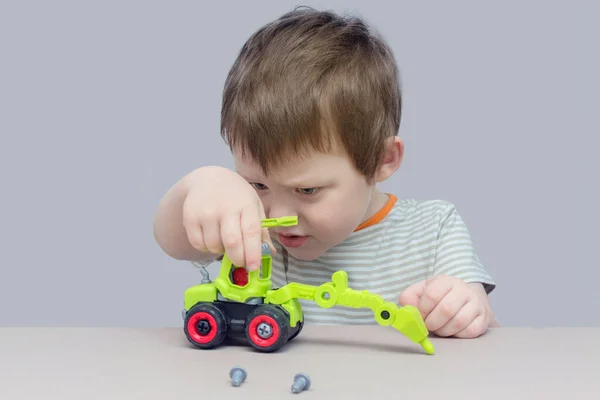 Jongen Monteerde Een Speelgoedgraafmachine Uit Onderdelen Met Behulp Van Een — Stockfoto