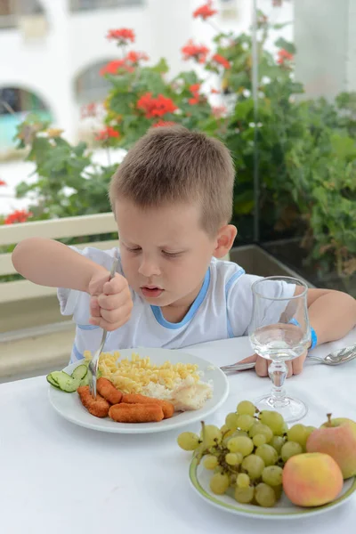 Het Kind Zit Aan Een Tafel Eet Met Eetlust Een — Stockfoto