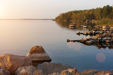 Rossi 'nin manzarası. Sonbahar günbatımı ya da gölün üzerinde gün doğumu. Kuzeyin vahşi yaşamı. Finlandiya Körfezi, deniz kıyısında büyük taşlar.