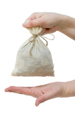 El, bir torba dolusu bozuk parayı tutar, bir avuç içi de aşağıdan yerleştirilir. Dikey fotoğraf, tecrit, büyük plan. Kavram - tasarruf, hazine, maaş.