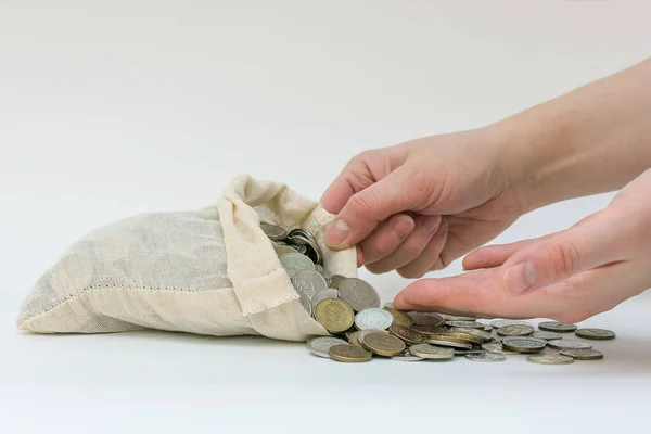 female hands in close-up, taking or adding coins from a bag of money. Russian coins. Horizontal photo, white background