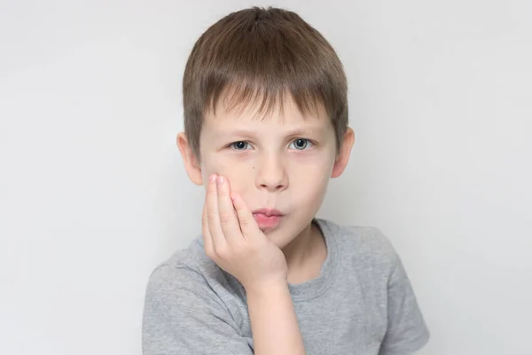 Het Kind Houdt Zijn Wang Met Zijn Hand Vast Wat — Stockfoto