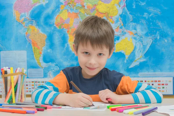 Cute Preschooler Boy Sits Table Background World Map Studies Geography — Stock Photo, Image