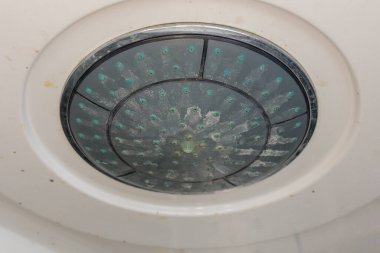 Çiçekli eski duş başlığı. Kirli plastik duş başlığı. Su tesisatında kireç ölçeği. Yatay fotoğraf