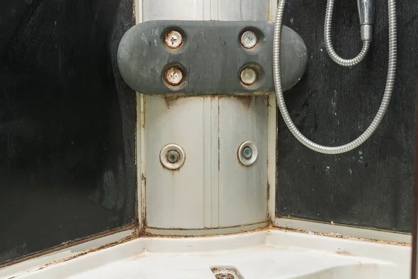 close-up of a dirty shower cabin, everywhere there is dirt, fungus, mold. Dirty joints and corners. Disgusting, the hydromassage holes are clogged. Horizontal photo.