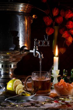 Mum ışığında limonlu ve şekerli bir semaverden akşam çayı.