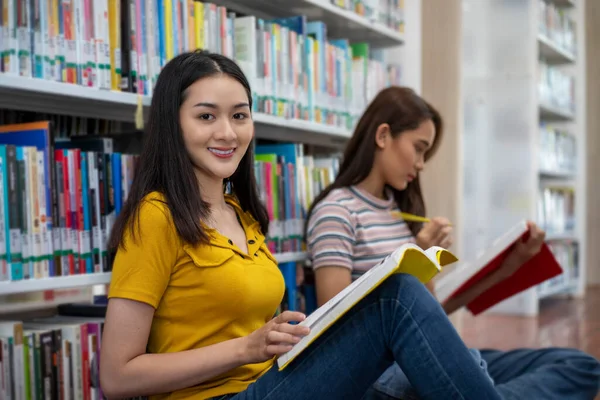 Asiáticas Estudiantes Con Amiga Sonríe Lee Libro Haz Deberes Biblioteca — Foto de Stock