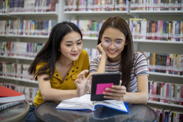 Asiáticas Estudiantes Con Amiga Sonríe Lee Libro Haz Deberes Biblioteca — Foto de Stock