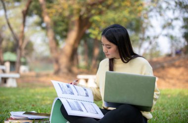Asyalı öğrenciler evdeki koronavirüs salgını ve karantina sırasında evdeki bahçede çalışmak ve çalışmak için bilgisayar ve tablet kullanıyorlar.