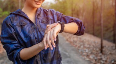 Asyalı kadınlar spor saatini başlatmak ya da koşmak için akıllı saate basıyorlar.