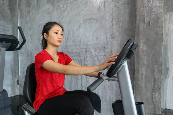 Female on gym bike doing cardio exercise.