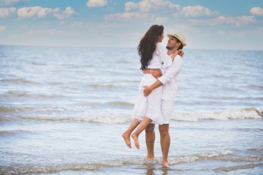 Kumsalda el ele tutuşan mutlu romantik çiftler.