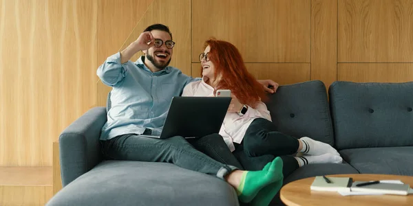 Mooi stel dat samen tijd doorbrengt thuis, met laptop en smartphone — Stockfoto