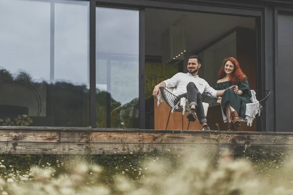Felice giovane coppia seduta sulla terrazza della loro casa di campagna — Foto Stock