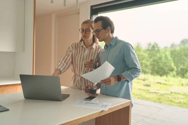 Succesvol koppel op de keuken met laptop en smartphone — Stockfoto