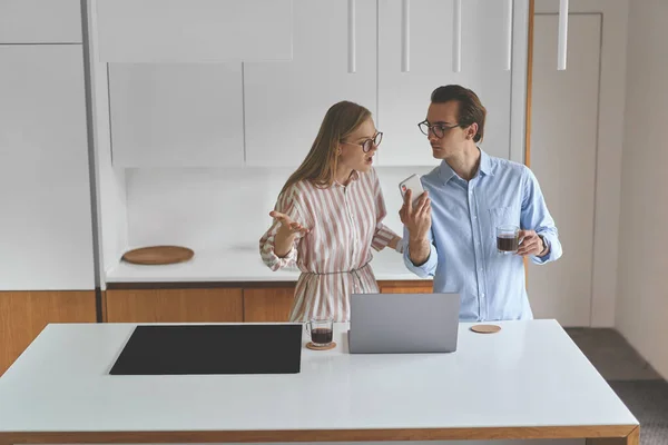 Vooraanzicht van paar staan op de moderne keuken en werken vanuit huis — Stockfoto