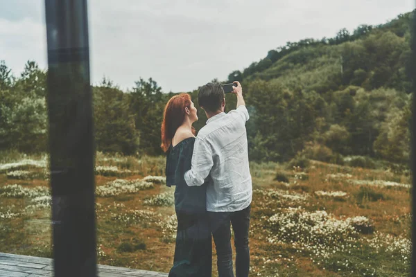 Bakåt bild av unga familj par gör selfie på smartphone på terrassen — Stockfoto