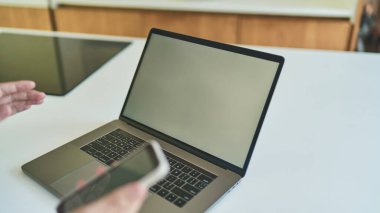 Bilgisayarda ve akıllı telefonda çalışan bir adamın görüntüsü.