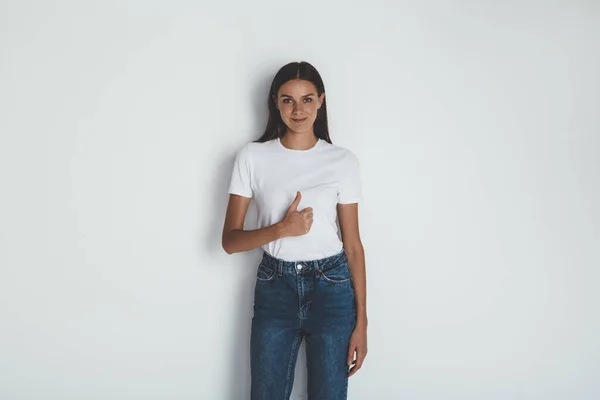 Вид спереди на девушку в джинсах и пустой белой футболке — стоковое фото