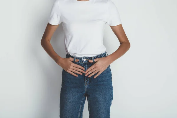 Обрезанный портрет молодой женщины в джинсах и пустой белой футболке — стоковое фото
