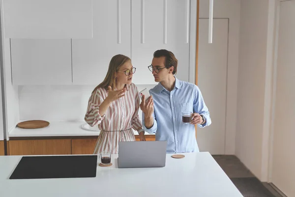 Vooraanzicht van paar staan op de moderne keuken en werken vanuit huis — Stockfoto