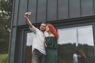 Genç çift terasta selfie çekerken eğleniyor.