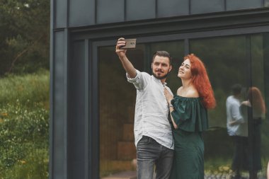 Genç çift terasta selfie çekerken eğleniyor.