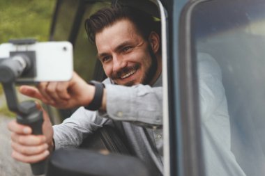 Akıllı telefondaki vlog 'u sabit kamerayla kaydeden başarılı adamın portresi