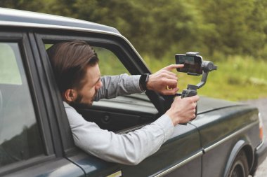 İş adamlarının yan görüntüsü sabit kameralı akıllı telefon kullanarak seyahat fotoğrafları