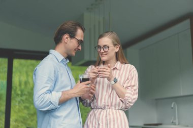 Genç bir çift kahve içiyor ve mutfakta aile işlerini tartışıyorlar.