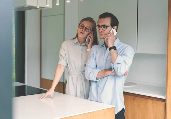 Jong familie paar werken vanuit huis en praten via de telefoon — Stockfoto