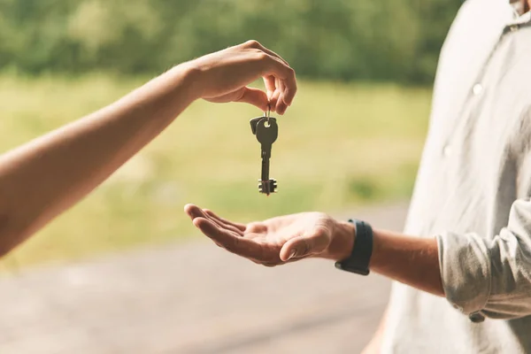 Close-up van vrouwelijke makelaar geven sleutels aan man — Stockfoto