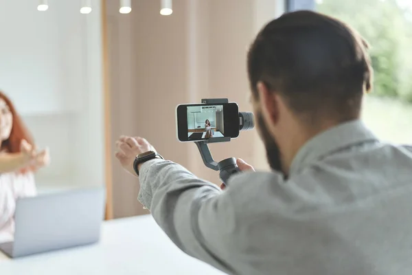 Achteraanzicht van millennial vloggers paar opname vlog op smartphone en steadycam — Stockfoto