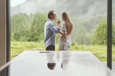 Terasta kahve içen genç bir aile manzarası.