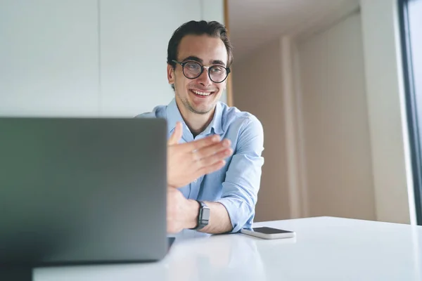 Mladý muž se usmívá přes notebook — Stock fotografie