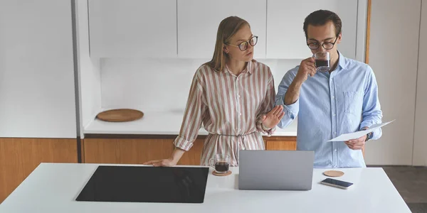 Vooraanzicht van paar staan op de moderne keuken en werken vanuit huis — Stockfoto