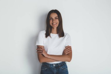 Basit tişörtlü neşeli kadın kameraya gülümsüyor.