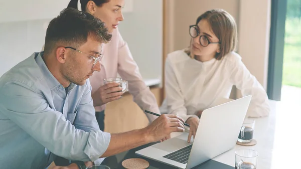 Drie jonge freelancers woking met laptop — Stockfoto