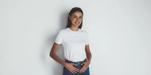 Cheerful woman in basic t-shirt smiling at camera — Stock Photo, Image