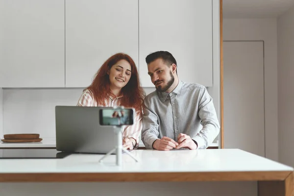 Front view of successful couple making live broadcast at smartphone and tripod — Stockfoto