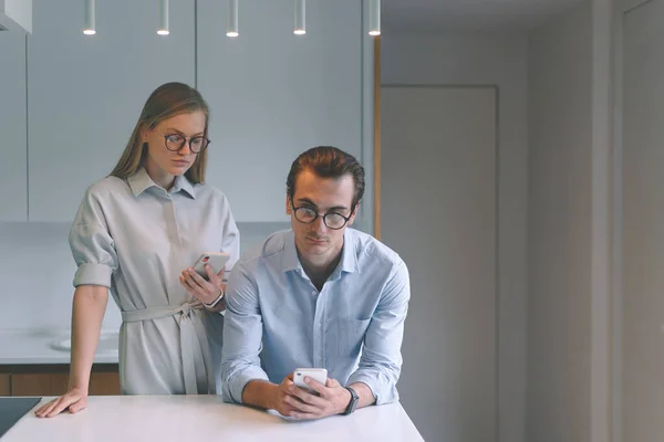Serieuze zakenmannen paar werken vanuit huis online met smartphones — Stockfoto