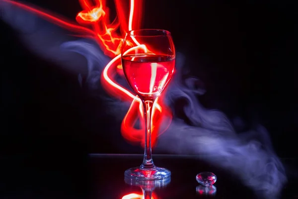 Glass of wine and red light painting — Stock Photo, Image