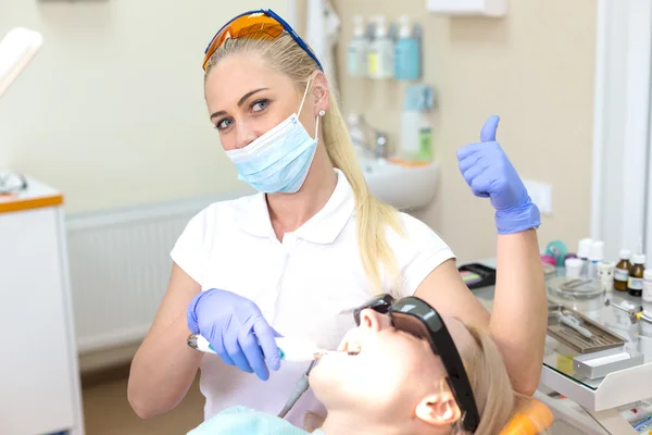 Woman dentist successfully treating tooth — Stock Photo, Image