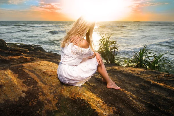 Женщина сидит с головой в солнечной вспышке — стоковое фото
