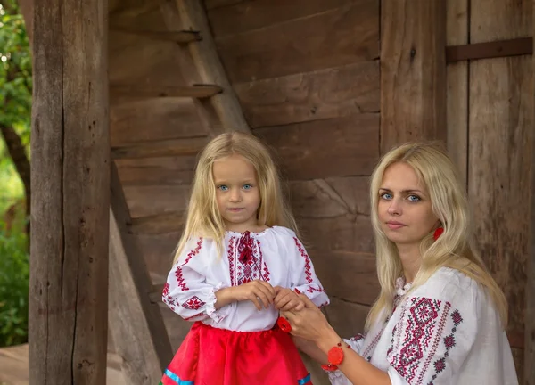 Oekraïense moeder en haar dochter in de buurt van oud huis — Stockfoto