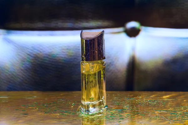 Perfume bottle on the golden and black background — Stock fotografie